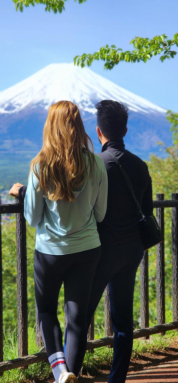 Sophie and Daniel from Germany looking at snow-capped Mount Fuji from a forest viewpoint