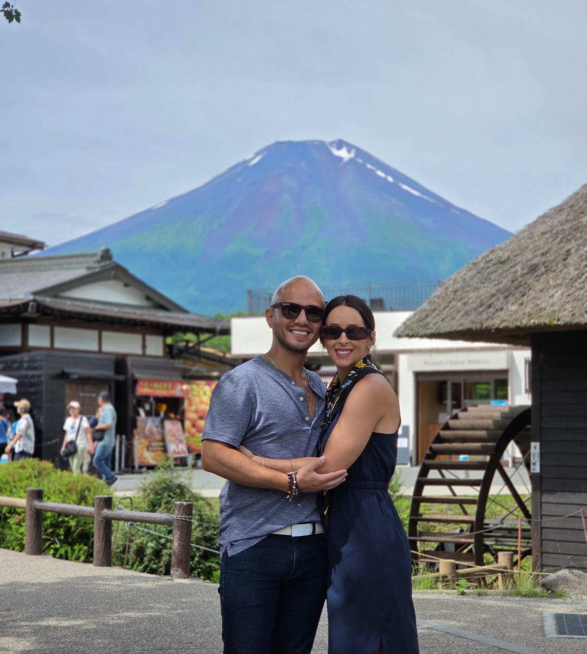 Marco and Giulia from Italy at Oshino Hakkai village with Mount Fuji behind the thatched roofs